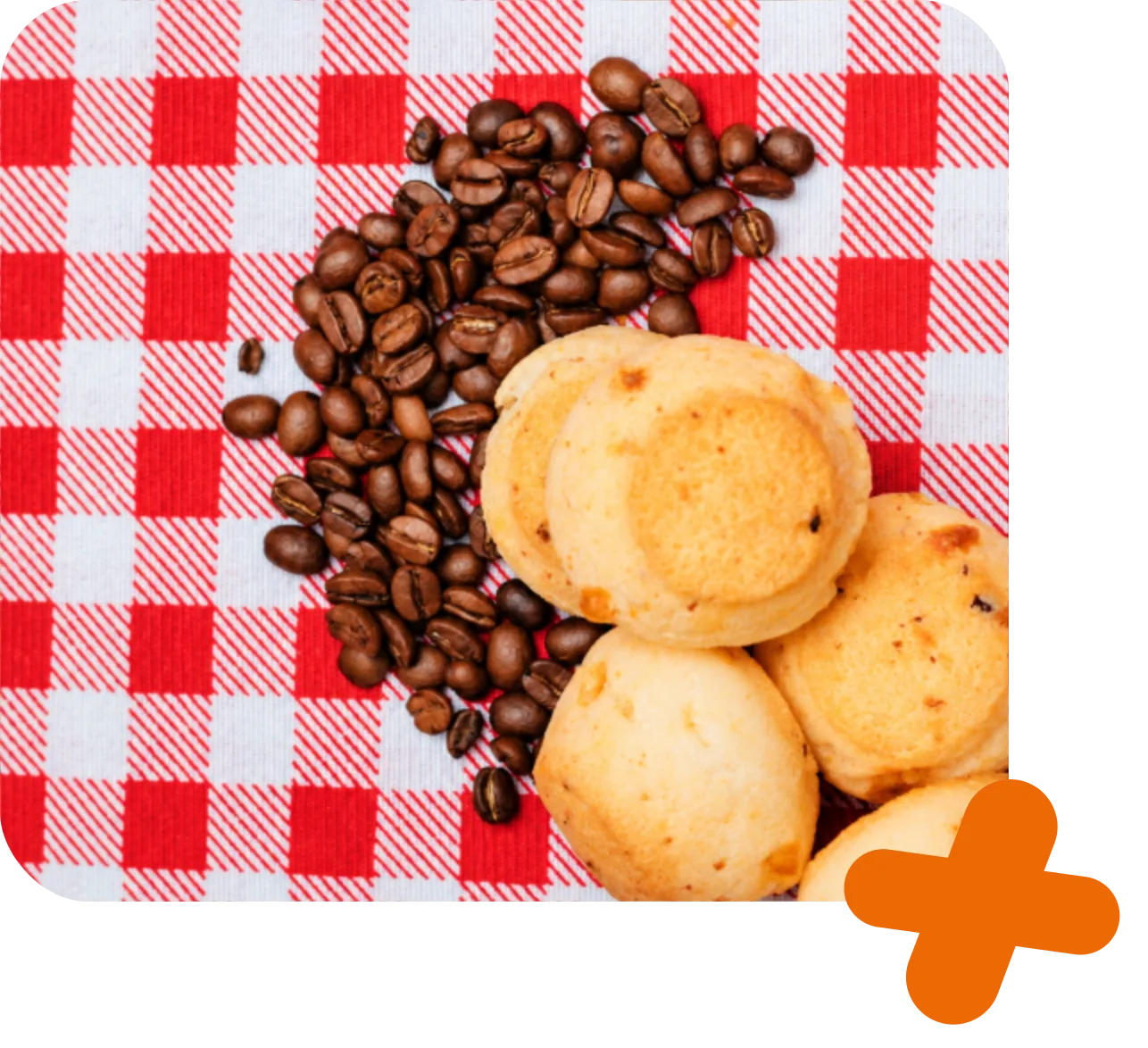 Pães de queijo sobre toalha xadrez, acompanhados de grãos de café